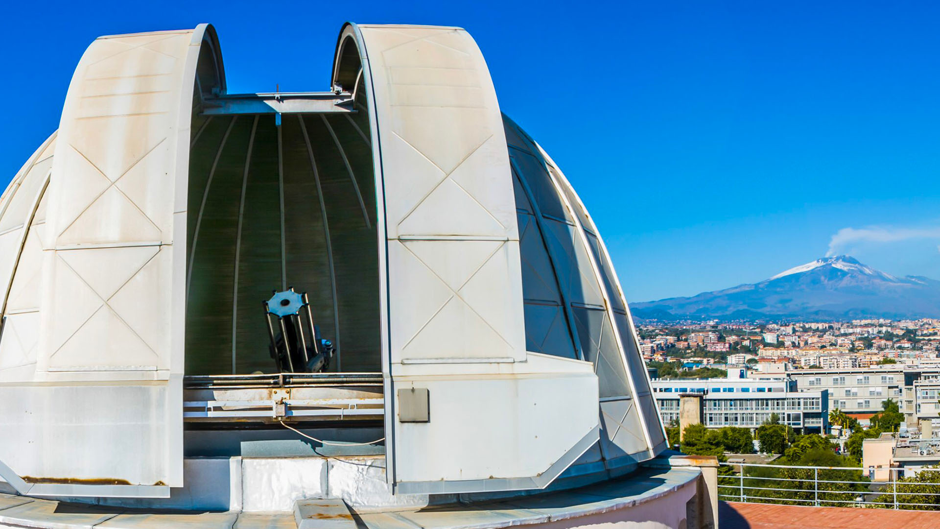 Foto che mostra in primo piano Osservatorio solare di Catania e sullo sfondo l'Etna